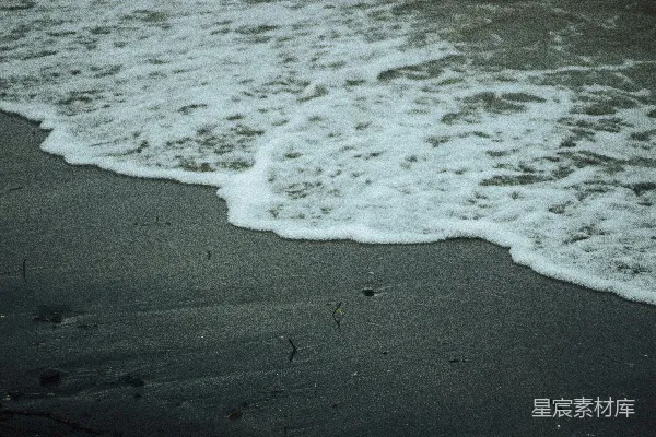 高清摄影 海浪轻轻拍打着黑暗的沙滩。