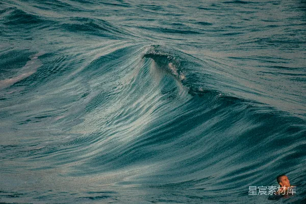 高清摄影 一个人在海浪拍打岸边的地方游泳。
