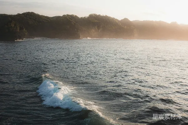 高清摄影 夕阳下，海浪拍打岸边。