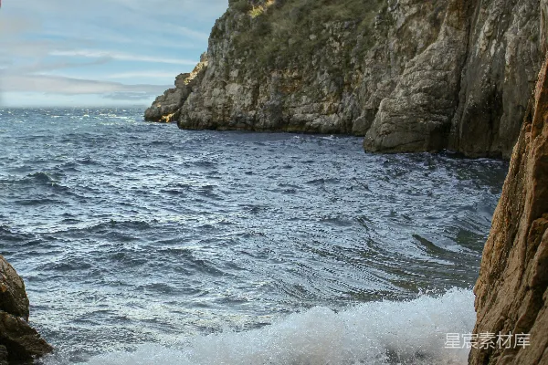 高清摄影 一个岩石海滩，背景中有一大块岩石地貌。