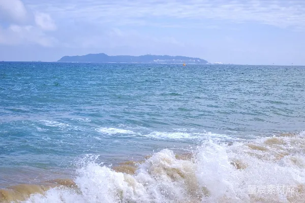 高清摄影 海浪拍打着沙滩，远处是岛屿。