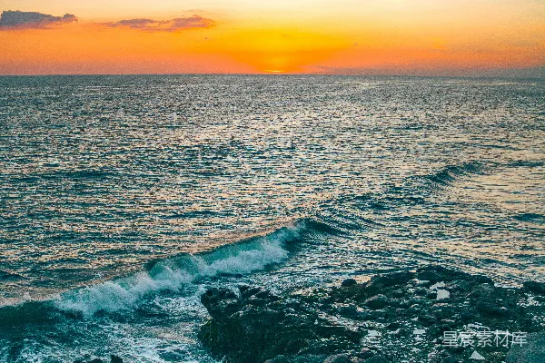 高清摄影 夕阳映照在海面上，岩石海岸线清晰可见。