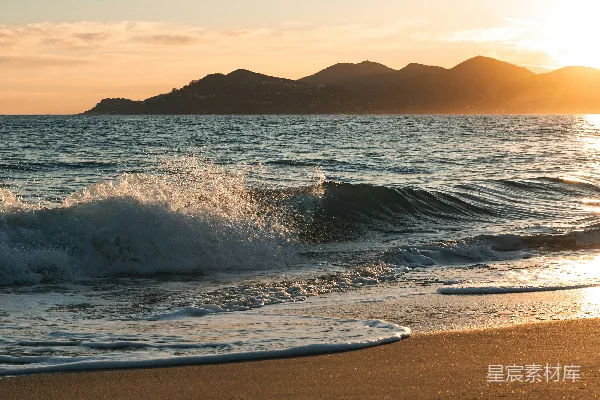 高清摄影 夕阳下，轻柔的海浪拍打着沙滩。