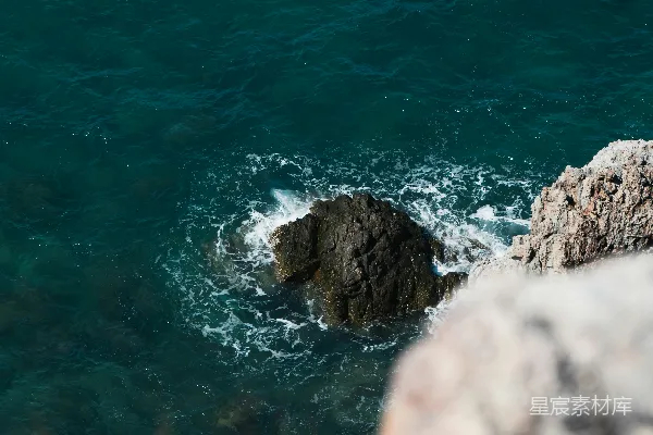 高清摄影 海浪拍打着岩石海岸，从高处的悬崖落下。