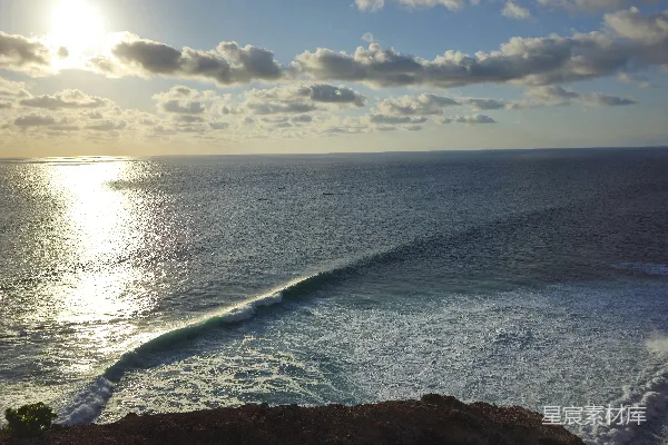 高清摄影 阳光反射在岩石海岸附近翻滚的海浪上。