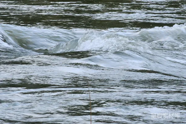 高清摄影 湍急的河流水流中泛着白色泡沫和涟漪。