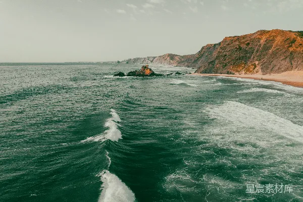 高清摄影 海浪在沙滩和悬崖附近拍打。