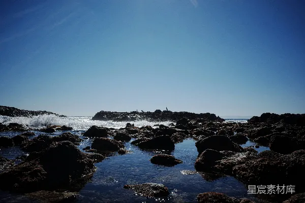 高清摄影 太阳在岩石海滩上闪耀。