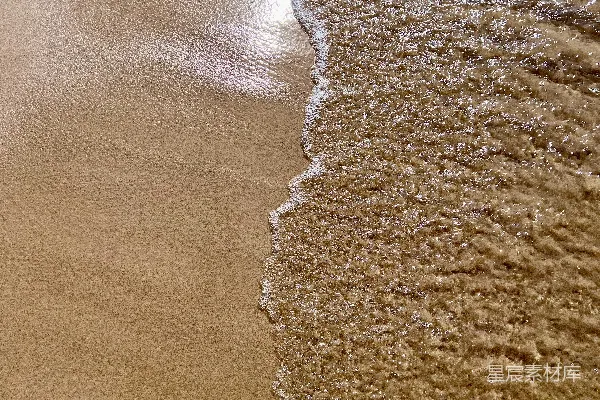 高清摄影 海滩上湿沙上轻轻的波浪。
