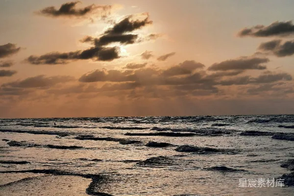 高清摄影 夕阳映照在海洋上，波浪轻轻拍打着岸边。