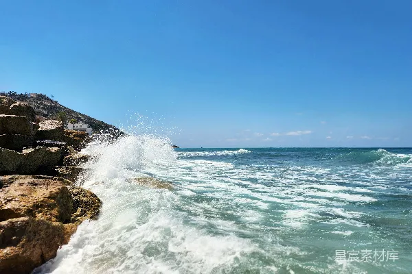 高清摄影 在阳光明媚的一天，海浪冲撞着岩石。
