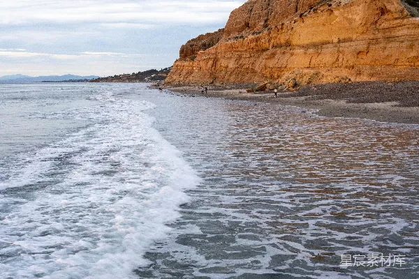 高清摄影 海浪拍打着沙滩，悬崖矗立。