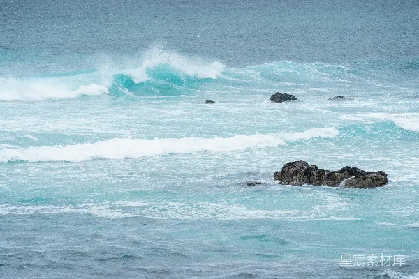 高清摄影 蓝色的海浪拍打着海中的岩石。