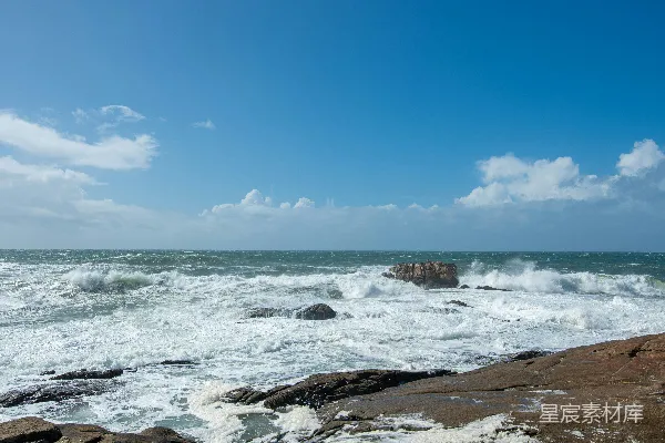 高清摄影 波浪拍打着岩石海岸，在蓝天之下。