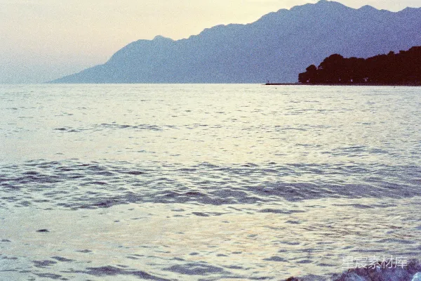 高清摄影 一个带着冲浪板的人走在海滩上。