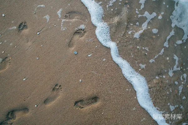 高清摄影 沙滩旁边海浪旁的两个脚印