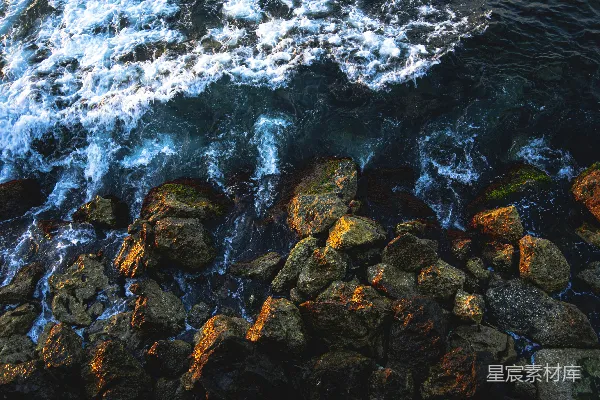 高清摄影 夕阳下，海浪拍打着岩石岸。