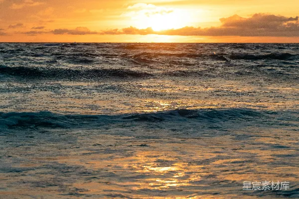 高清摄影 夕阳正垂落在海洋上，波浪起伏。