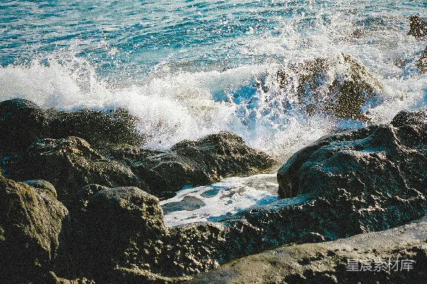 高清摄影 白天，海浪拍打着黑色岩石形成的礁石。