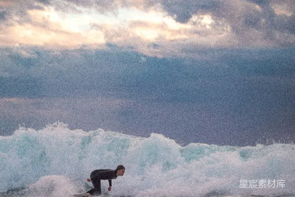 高清摄影 穿着黑色潜水服的男人在白天的海浪中冲浪。