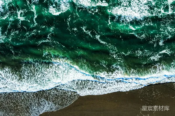 高清摄影 一张海滩的俯瞰图，海浪拍打着沙滩。