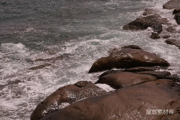 高清摄影 海浪拍打着海岸边湿漉漉的黑岩石。