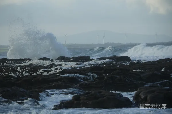 高清摄影 波浪在阴云密布的天空下拍打着岩石海岸。