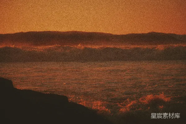 高清摄影 夕阳下，海浪拍打着岩石海岸。