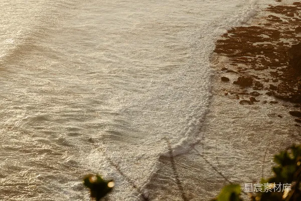 高清摄影 海浪轻轻拍打着岩石海岸，在夕阳下显得格外宁静。