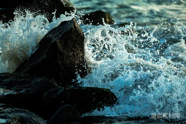 高清摄影 海浪拍打在岸边的暗色岩石上