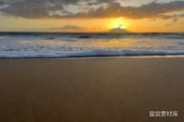 高清摄影 海浪拍打着海滩，夕阳洒下金色的光辉。