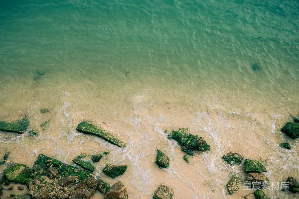 高清摄影 清澈的海水拍打着沙质海滩上的岩石。