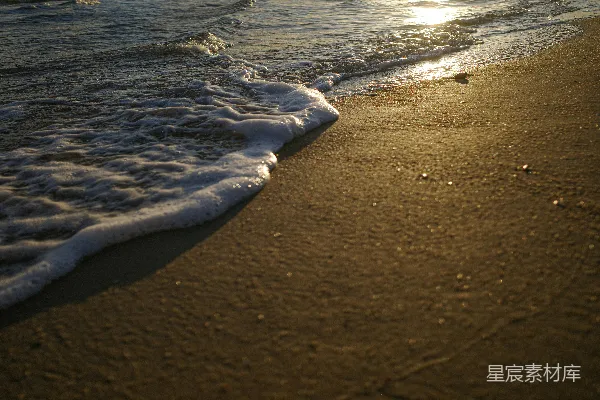 高清摄影 夕阳下，温柔的海浪拍打着沙滩。