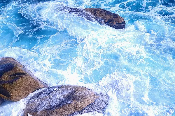 高清摄影 海浪拍打着蓝色海洋中的岩石。