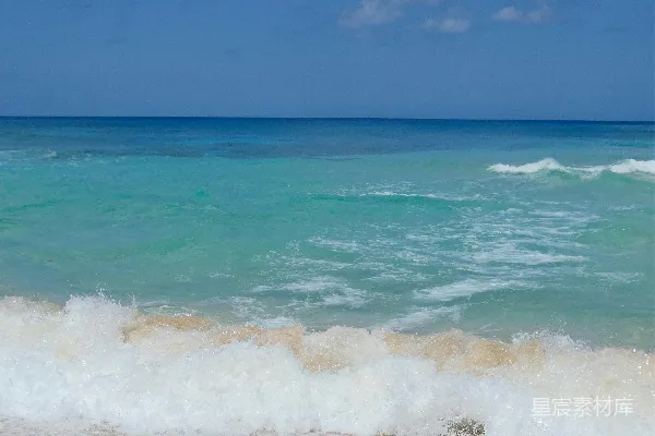 高清摄影 海浪拍打着蓝天下的沙滩。
