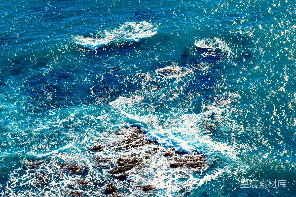 高清摄影 蓝色的海洋波浪拍打着岩石，形成一片沙滩。