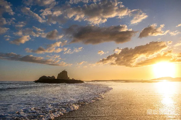 高清摄影 夕阳正落海平线上，远处有一座小岛。