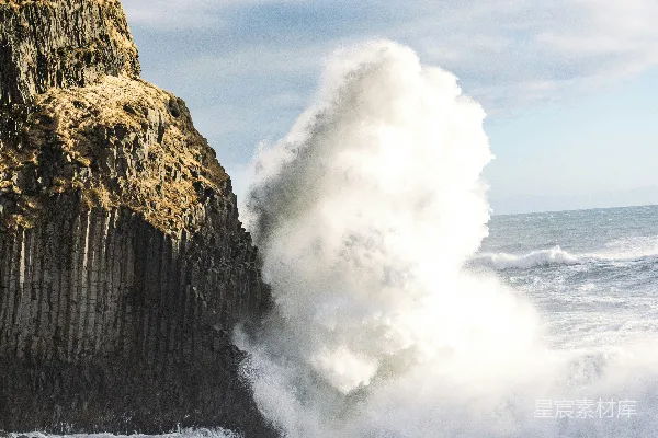 高清摄影 一股巨大的海浪猛烈地撞击着一堵高耸的玄武岩悬崖。