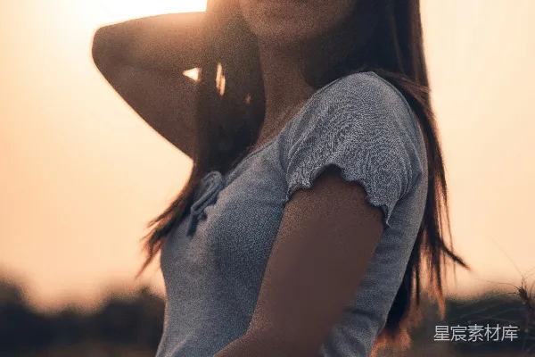 高清摄影 一个女人站在麦田中，夕阳西下。