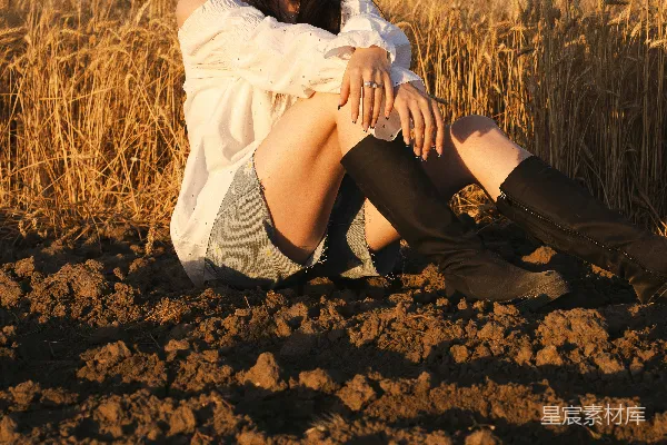 高清摄影 女人坐在田野里，享受着金色的时光。