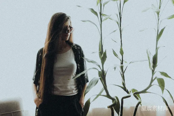 高清摄影 一个女人站在房间里的植物旁边。