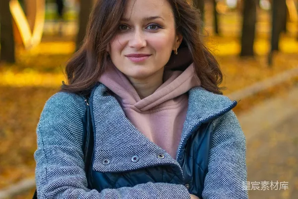 高清摄影 一个女人站在公园里，双臂交叉。
