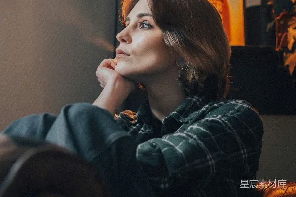 高清摄影 一个女人坐在椅子上，手托着下巴。
