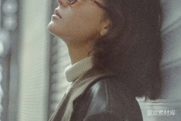 高清摄影 一个戴着眼镜的女人靠在墙上。