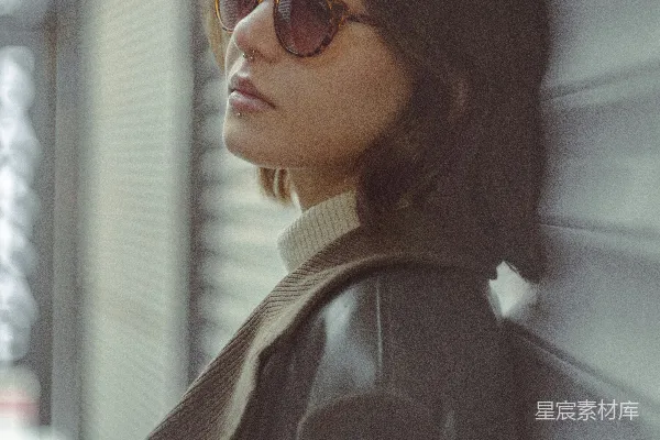 高清摄影 戴着太阳镜的女人靠着墙。