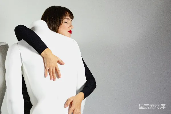 高清摄影 一个穿着黑白相间衣服的女人抱着一把白色的椅子。
