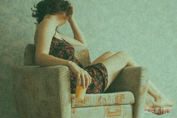 高清摄影 穿着黑色和红色花卉连衣裙的女人坐在棕色沙发椅上。