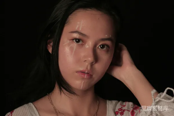 高清摄影 一个女人摆姿势拍照，手放在头上。