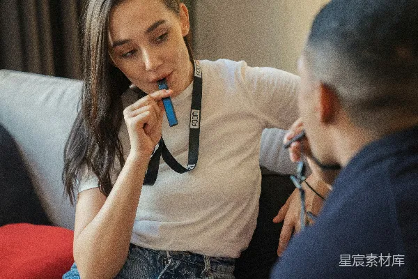 高清摄影 一个女人坐在沙发上，嘴里拿着牙刷。