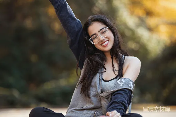 高清摄影 微笑的女子在户外拿着篮球摆姿势。